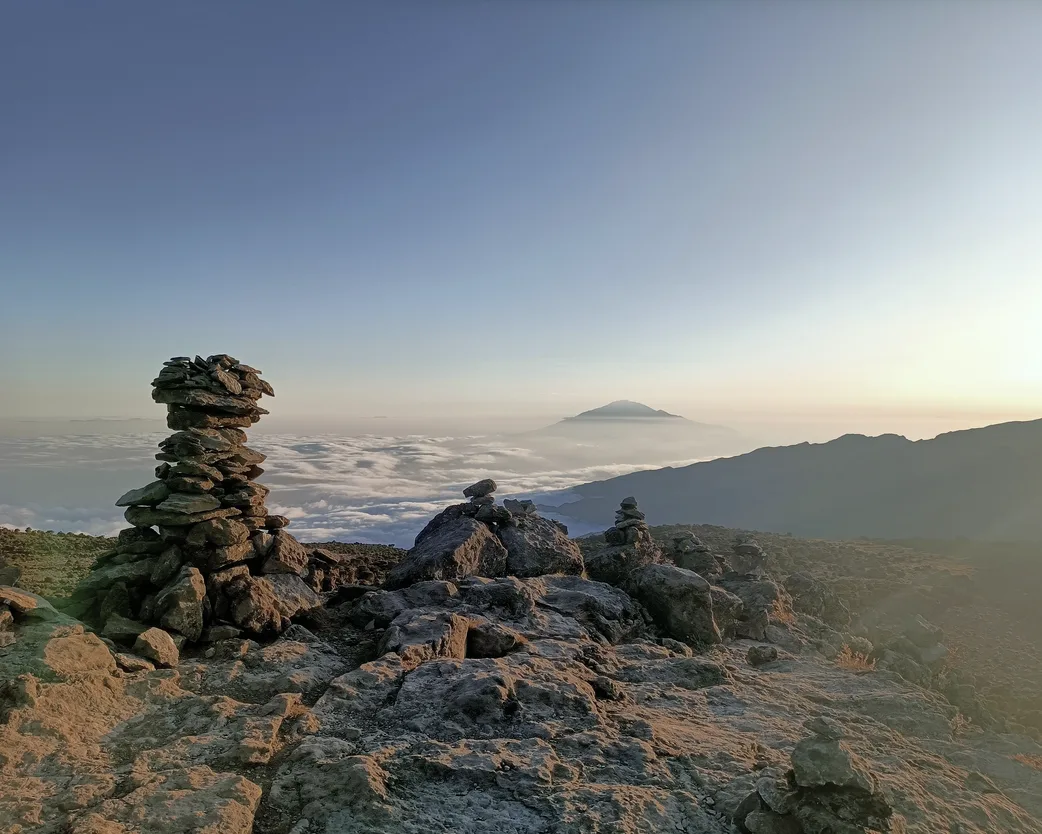 A stone cairn on the ridge above a sea of cloud, Kilimanjaro