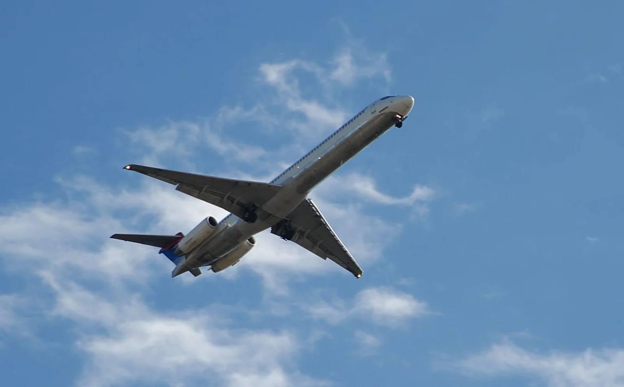 An airliner climbing through a blue sky