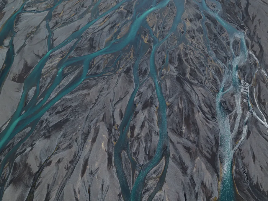 Aerial view of a braided river spreading across a plain